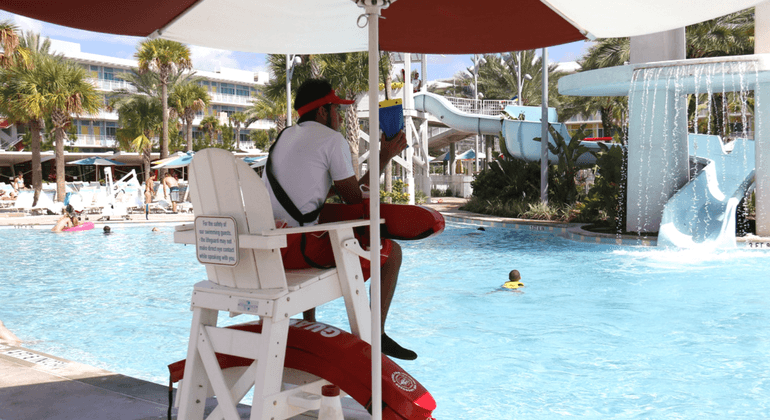 Male lifeguard on duty at a hotel pool 